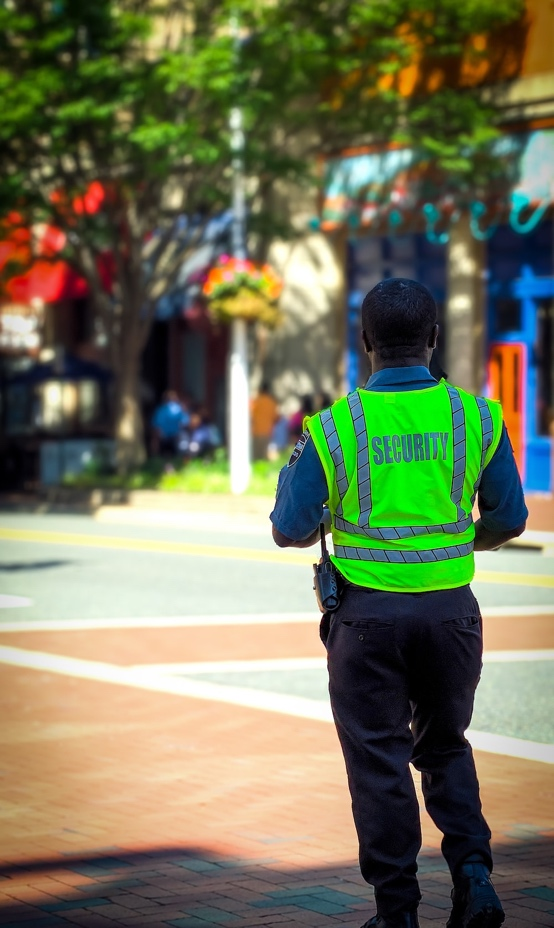A Security Officer Patrolling a Street on Foot