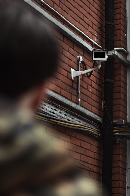 An image of a man standing in front of a surveillance camera