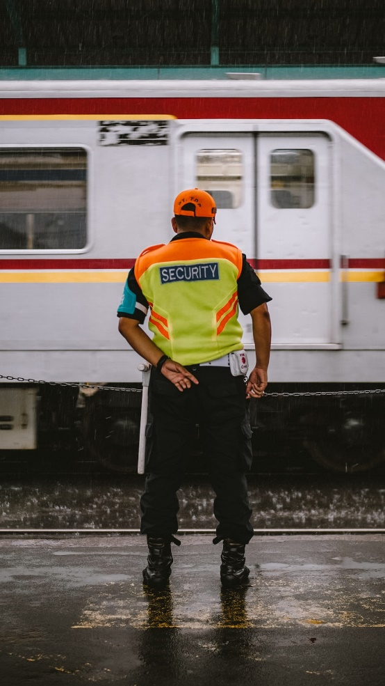 An image of a security officer in front of a moving train