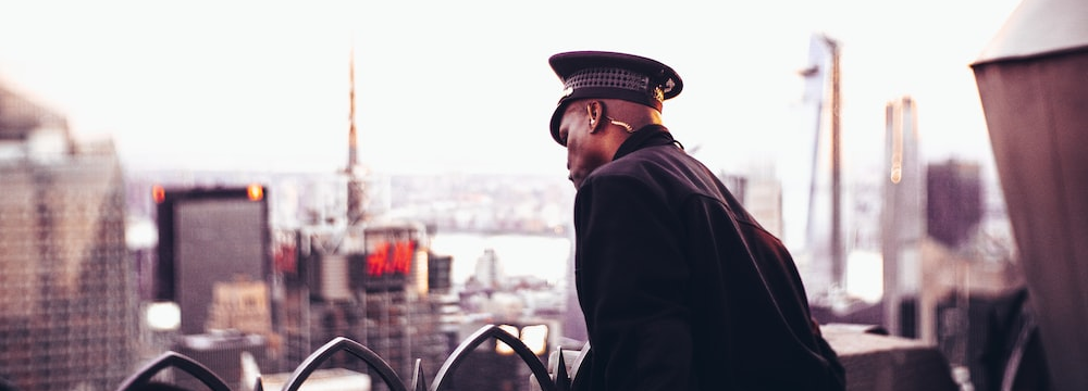 A security officer looking down from the roof of a building