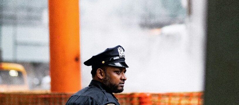 A security officer standing in a large place.