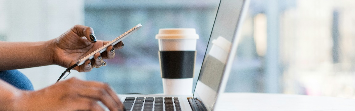 A workplace desk with someone working on the laptop.