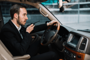 Security officer communicating via radio while seated in a patrol car